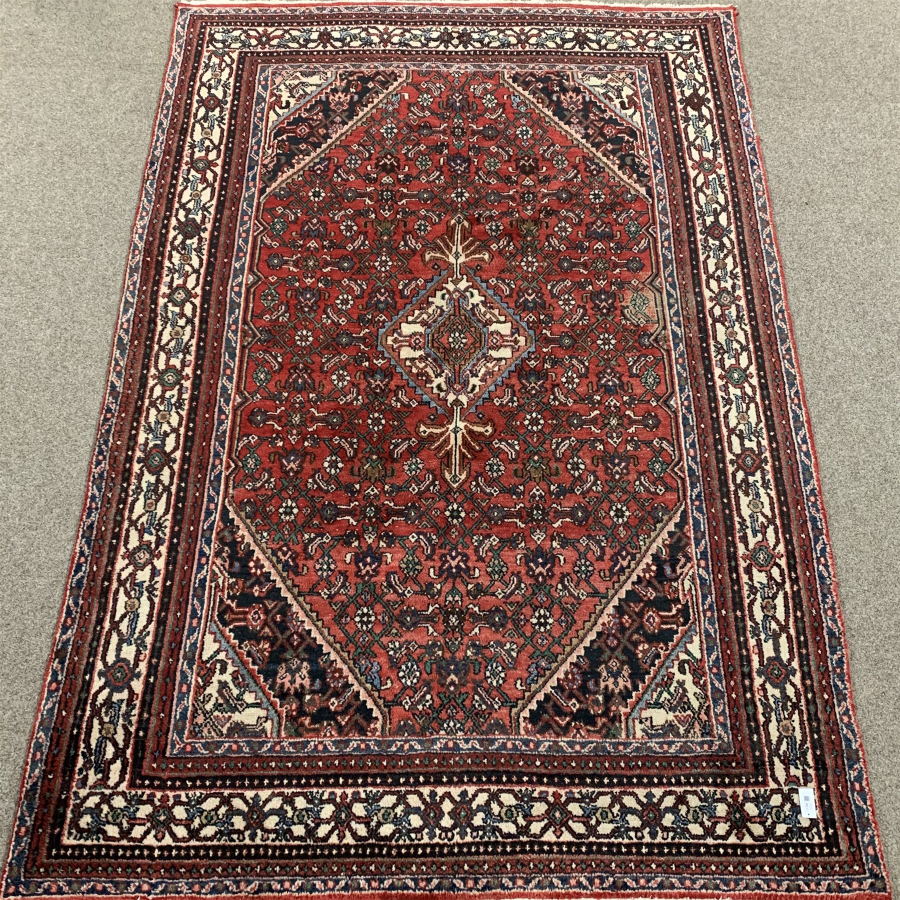 Large Persian red ground rug, central medallion, repeating border