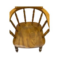 Late 19th century elm smoker’s bow armchair, curved top rails over turned spindle backs, shaped seats, raised on turned legs united by turned stretchers; together with a similar smoker’s bow armchair (2)