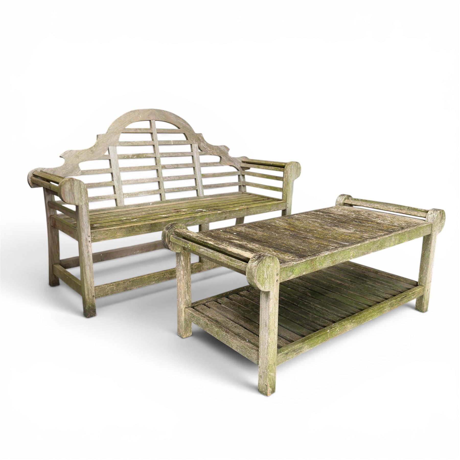 Lutyens design weathered teak garden bench with matching two-tier table, the bench with shaped arched and slatted back over rolled arms and slatted seat