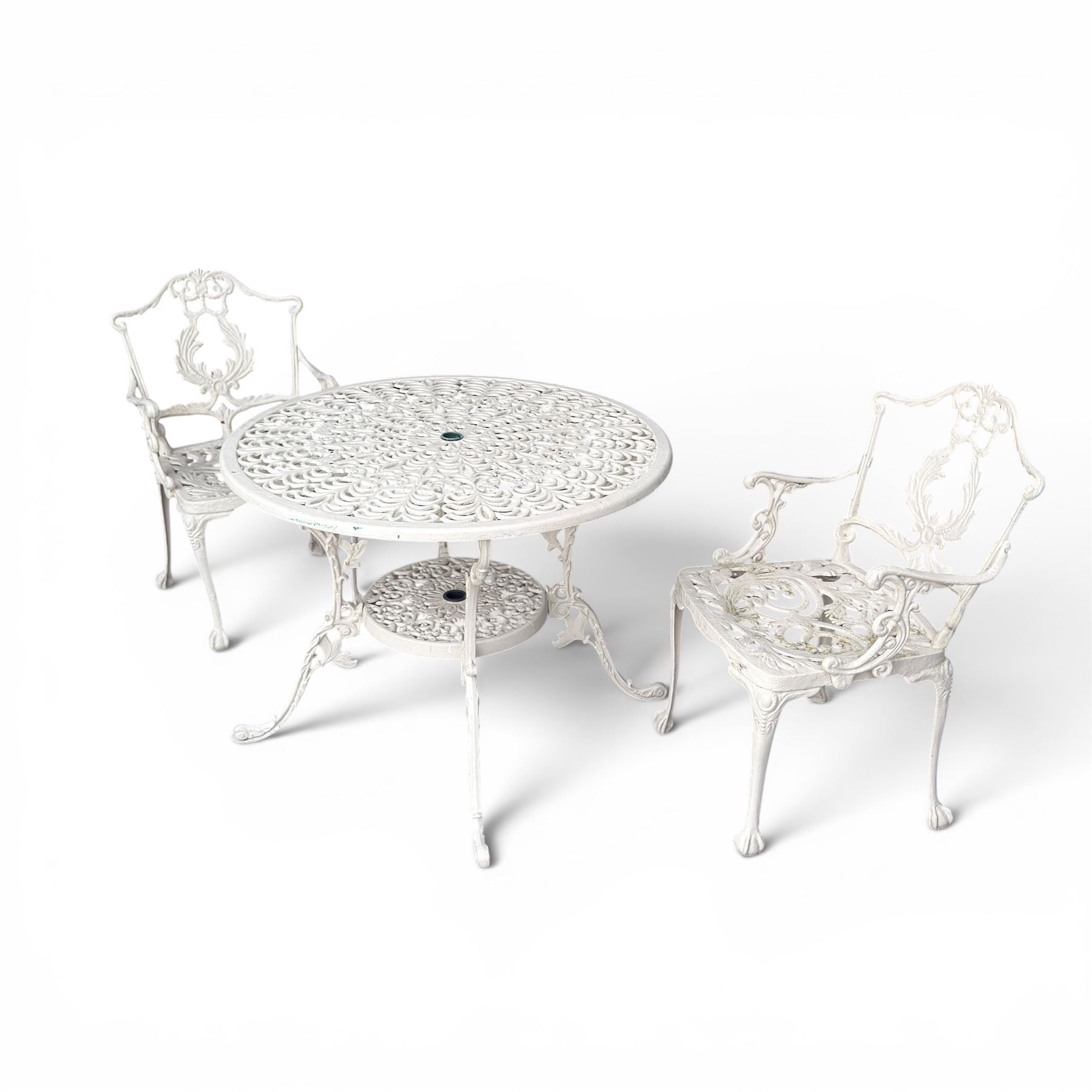 Victorian design cast aluminium garden table and twin armchairs featuring a pierced floral wreath splat, over a stylised scrolling acanthus leaf seat, including parasol