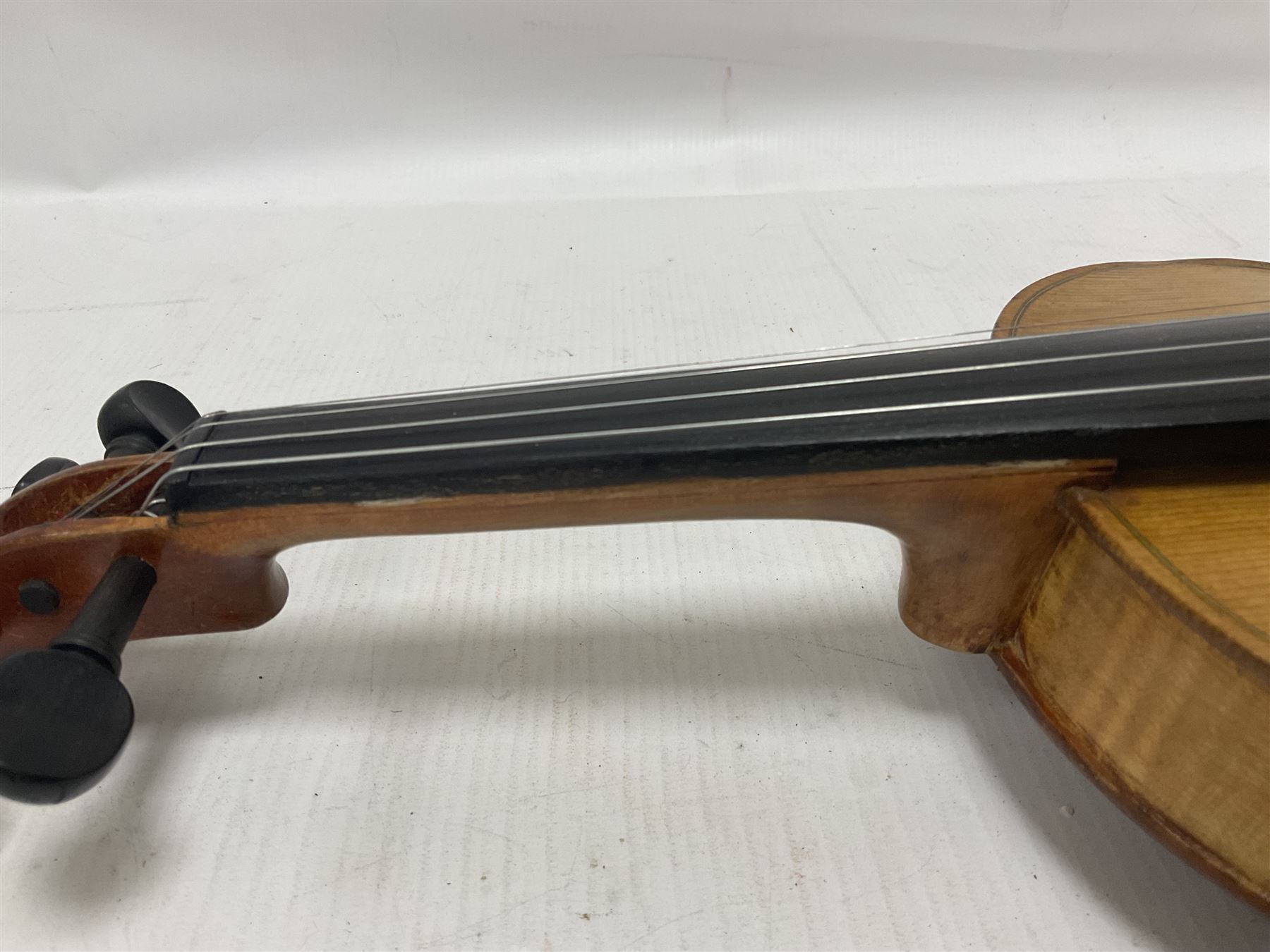 Copy of a full size Stradivarius violin, with an ebonised fingerboard, tailpiece and tuning pegs Length 60cm