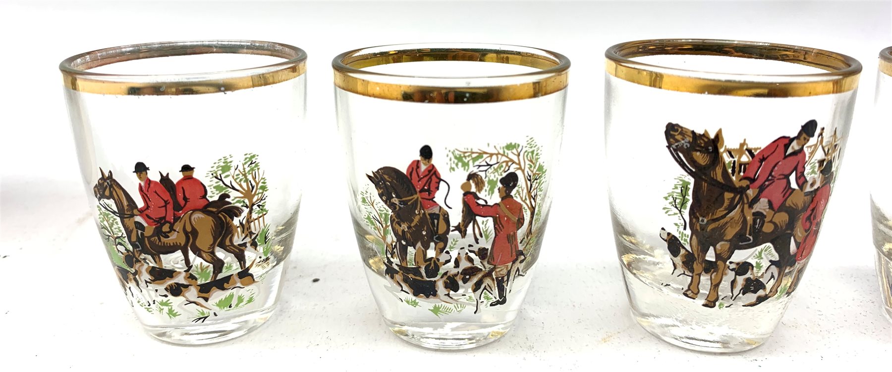  A collection of hunting related items, comprising a pair of Caverswall beakers, each with twin gilt fox head handles, H11.5cm, a limited edition Spode cabinet place depicting 'Drawing the Dingle' after J F Herring Sen, D24cm, and a set of six French shot glasses, decorated with huntsmen on horseback and hounds, H5.5cm.  