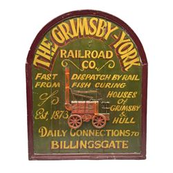 `The Grimsby-York Railroad Co.` painted wooden railway advertising sign 20th century, of planked construction with arched top and moulded border, decorated with an applied wood and metal image of an early steam locomotive in relief, the surrounding wording reading `The Grimsby-York Railroad Co., Fast Dispatch by Rail from Fish Curing Houses of Grimsby & Hull, Est. 1873, Daily Connections to Billingsgate`, 89 x 71cm
