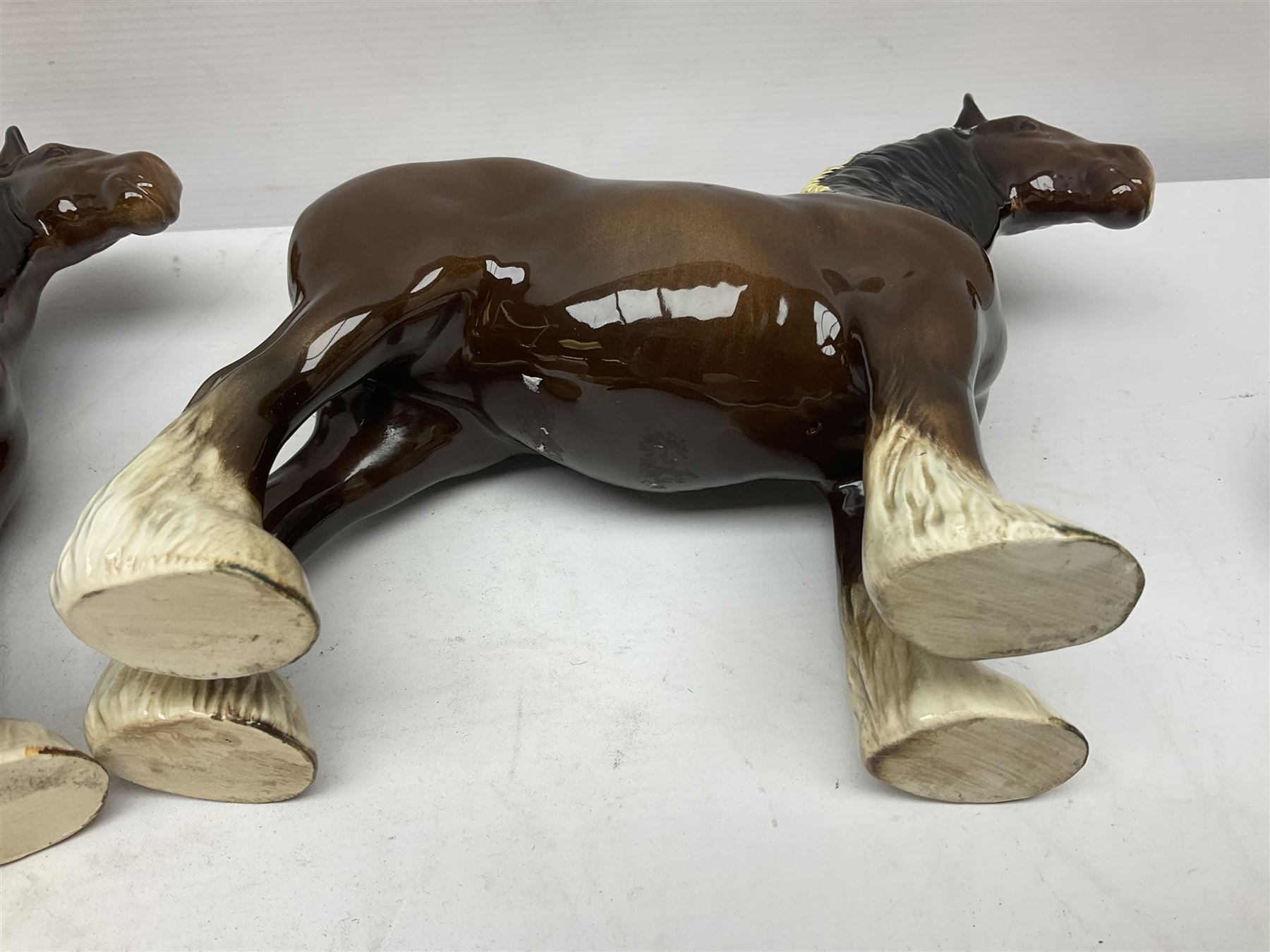 Four Beswick horse figures, comprising Quarter Horse, two Shires no 818 and matt palomino, together with Beswick donkey and Royal Doulton horse on a wooden plinth  