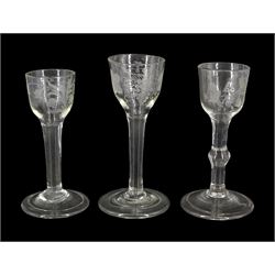 Three 18th century drinking glasses, the ogee bowls with engraved foliate and fruiting vine decoration, upon plain and knopped stems and folded conical feet, tallest H15cm
