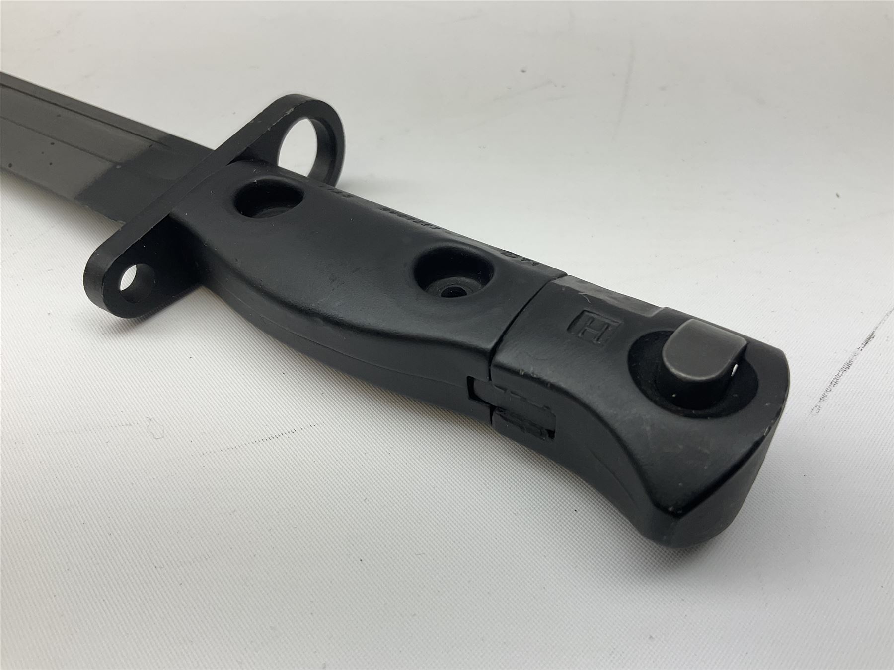 British Army L1A3 SLR Self Loading Rifle bayonet, with 20.5cm Bowie type fullered blade, hooked pommel with working push release button, grip secured by two deeply recessed rivets and marked L1A3 9600257 D71; in matching black scabbard L32.5cm overall