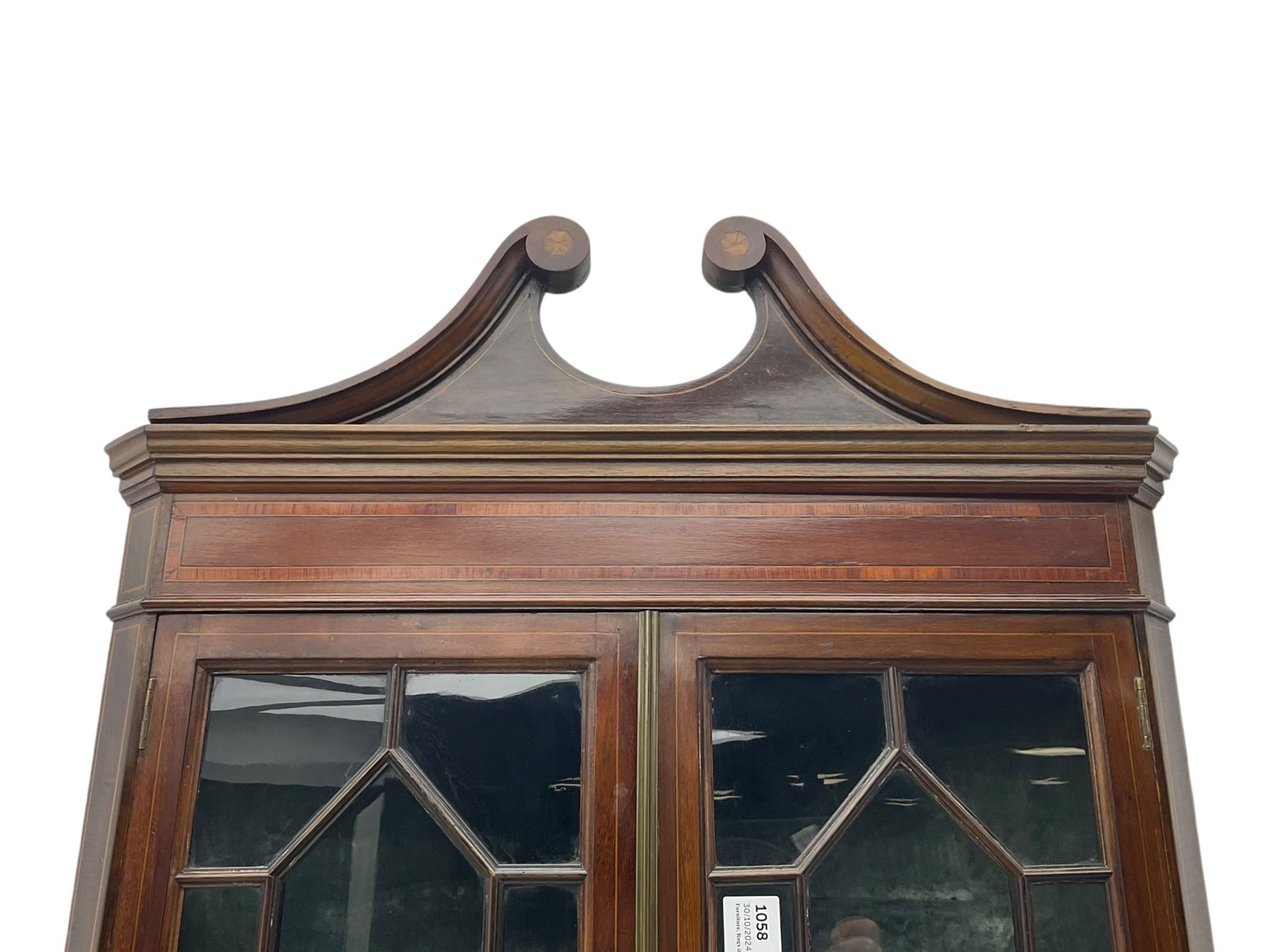 Edwardian mahogany corner display cabinet, scrolled swan neck pediment over astragal glazed doors, fabric lined interior, on cabriole feet 
