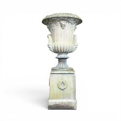 Cast stone classic garden urn, the rim decorated with leaves and berries, twin handles with face masks, raised on square base, stamped HGC