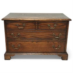 T & G style solid oak television cabinet, rectangular moulded top over two short and two long drawers with brass swing handles, the upper frieze drawer front hinged and fitted with stay to reveal pull-out shelf, open compartment above with circular cable aperture to rear, on bracket feet