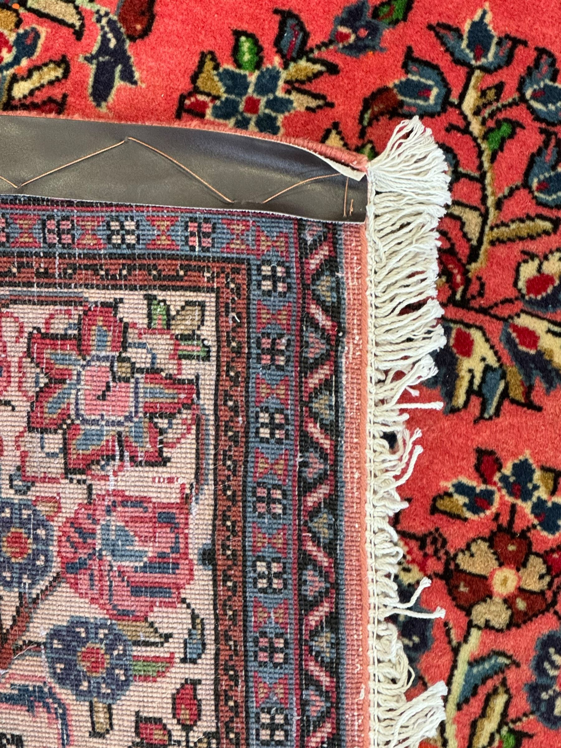 North West Persian Sarouk peach ground rug, the field decorated with floral bunches, pale ground border with repeating flower head motifs within guard stripes 