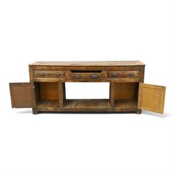 18th century rustic oak dresser base, with fielded panels and iron cup handles with embossed greek key and foliate detail, three short drawers above and open recess flanked by two cupboard doors, raised on stile supports