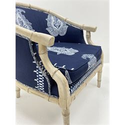 Pair contemporary tub shaped armchairs with faux bamboo wooden frames, distressed white paint finish, upholstered in blue and white paisley patterned fabric
