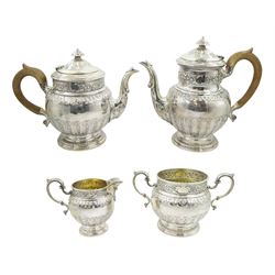 Early 20th century silver four piece tea set, comprising teapot, coffee pot, cream jug, and twin handled open sucrier, the teapot and coffee pot with curved wood handles, the milk jug and sucrier with acanthus capped scroll handles, each embossed and chased with foliate bands and raised upon circular footed base, hallmarked Sibray, Hall & Co Ltd (Charles Clement Pilling), coffee pot marked for London 1912, teapot, milk jug and scurier marked for Sheffield 1923, coffee pot H21.5cm, gross weight 70.89 ozt (2205 grams)