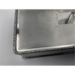 1920's silver table cigarette box, of rectangular form with engine turned decoration to the exterior, the hinged cover with central vacant rectangular panel and raised foliate rim, opening to reveal a gilt interior with later plush lining, hallmarked Charles Henry Dumenil, London 1923, H3.5cm L14.5cm D8.5cm