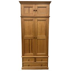 Solid pine double wardrobe, fitted with top box, enclosed by panelled doors, two short and one long drawer, on plinth base 