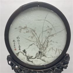 Late 19th century Chinese porcelain circular table screen painted with flowers and leaves and Chinese characters within a fluted hardwood frame D29cm; on hardwood stand carved with prunus blossom