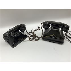 Two black Bakelite telephones of pyramid form with rotary dials, comprising The Telephone Demonstration Set model. 6al with base drawer and light bulb, and another larger with G.P.O FWR 58/2 stamped marks beneath, largest H18cm W20cm D16cm