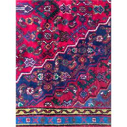 Northwestern Persian Hamadan hand-knotted rug, madder red field with a lozenge medallion enclosing an ivory centrepiece, indigo spandrels within an ivory border of stylized floral motifs between multiple guard borders 