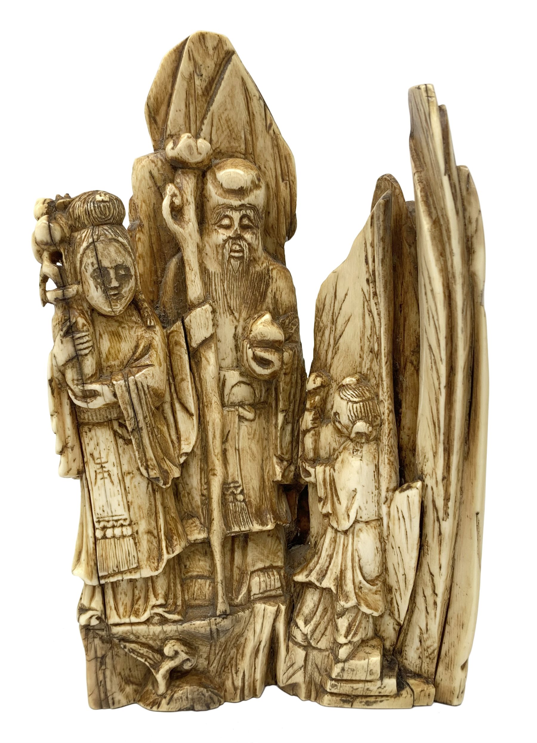 19th century Japanese carved mammoth ivory figure group, modelled as Fukurokuju and two attendants, carved verso with prunus, H17cm