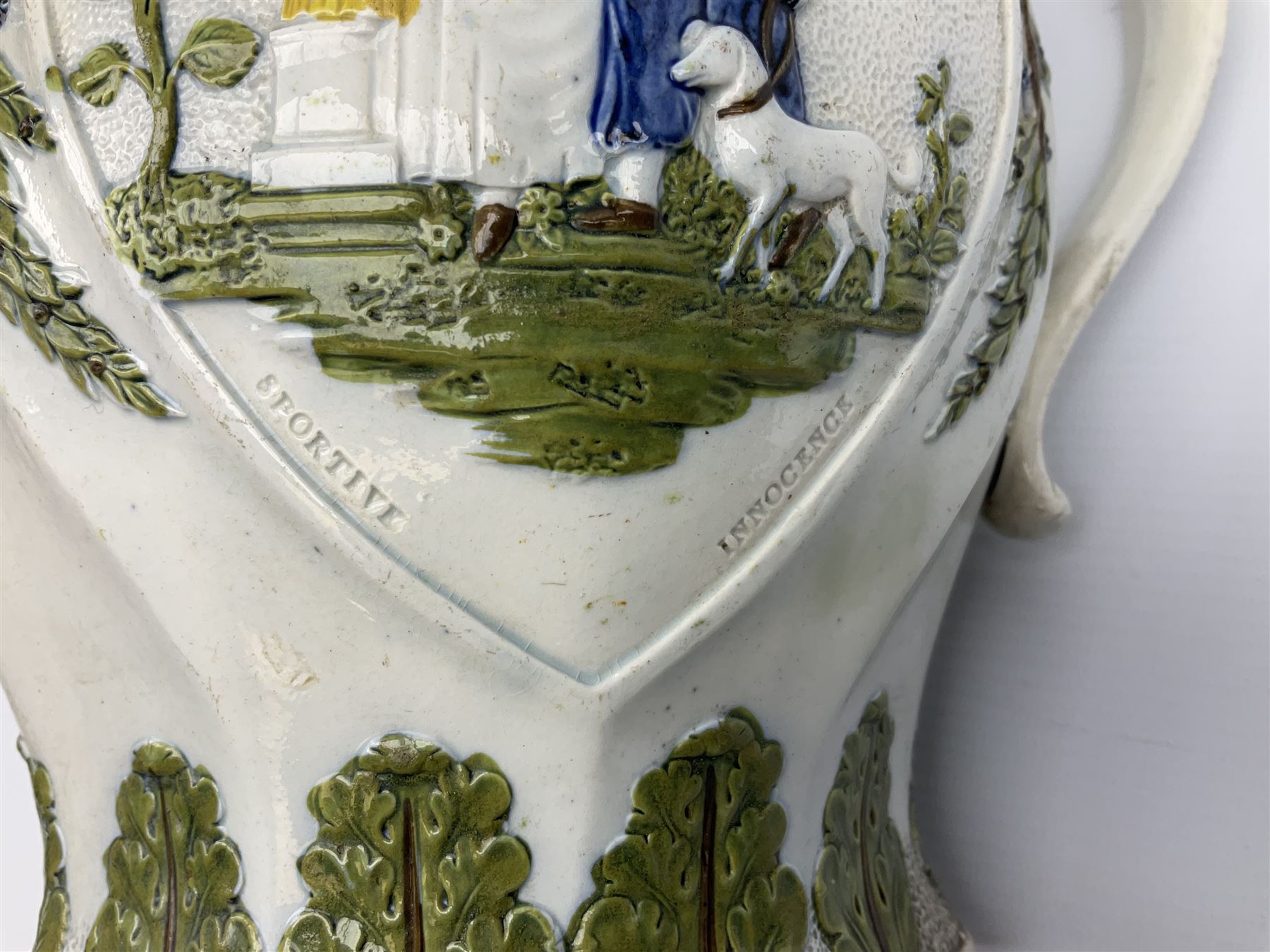 Early 19th century Prattware jug, circa 1800, decorated with two heart shaped panels of children, titled Sportive Innocence and Mischievous Sport, further decorated with acanthus and foliate borders, H22cm