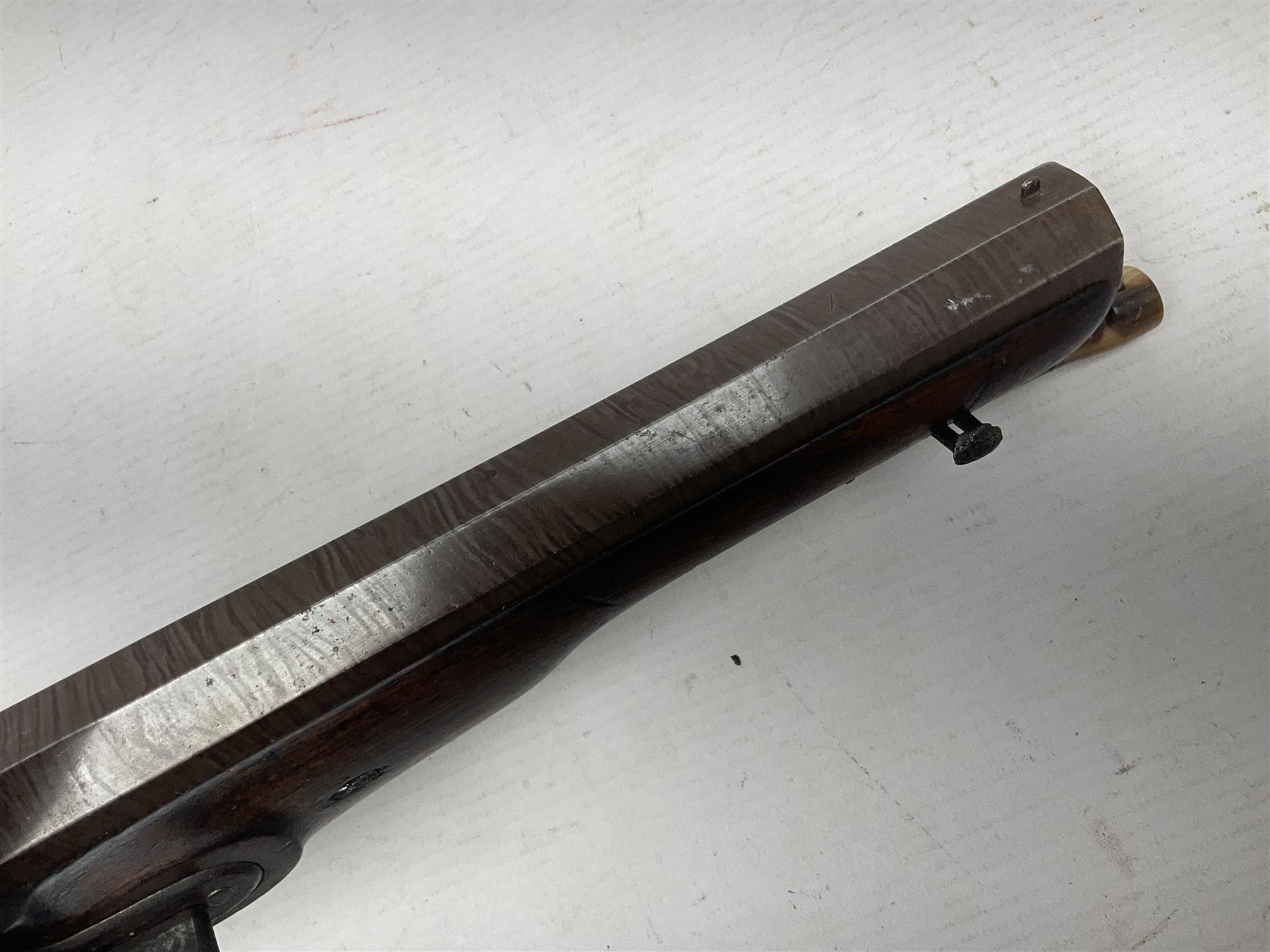 Early 19th century 16-bore flintlock single barrel travelling pistol, the 21.5cm stub twist octagonal barrel with two barrel pins and ramrod under, engraved lock plate with roller frizzen, engraved trigger guard with pineapple finial, walnut stoock with chequered grip L40cm overall