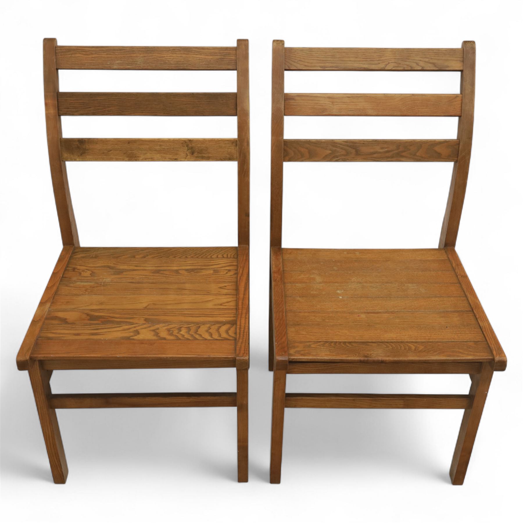 Treske of Thirsk - solid oak refectory dining suite, rectangular top with chamfered edge over trestle base united by a central stretcher, together with six matching slat back dining chairs, including two carvers, with panelled seats and square legs united by stretchers (H 87cm, W 62cm, D 57cm)