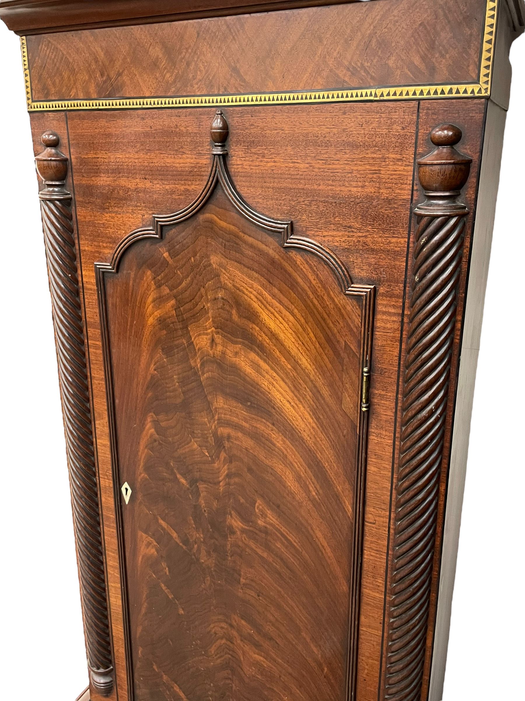Nathaniel Dumville of Stockport - 8-day brass inlaid mahogany longcase clock c1840, swans neck pediment with ball and spire finials and wooden paterae, recessed break arch hood door flanked by rope twist pilasters, trunk with conforming pilasters and gothic ogee topped door, canted plinth raised on bracket feet, fully painted break arch dial with moon work and spandrels depicting the four seasons, centre with Roman numerals, minute track, subsidiary date and seconds dials, matching stamped brass hands, four pillar movement with an anchor escapement, rack striking on a bell. With weights and pendulum.
The Dumville family were prevalent Cheshire clockmakers working in Stockport 1820-42.
