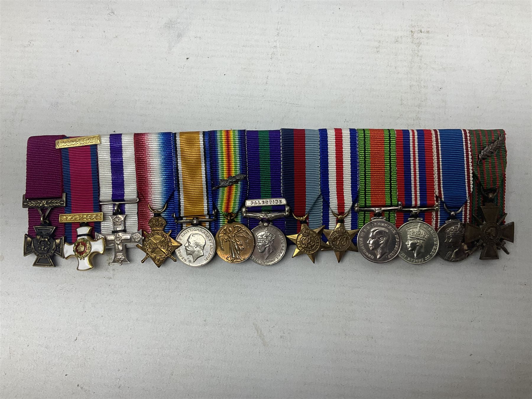 Captain (later Brigadier) Percy Howard Hansen V.C., D.S.O., M.C. 6th (Service) Battalion Lincolnshire Regiment - representative group of thirteen miniature dress medals comprising VC, DSO, MC, WW1 trio, GSM with Palestine clasp, four WW2 medals/stars, George VI Coronation Medal and French Croix-De-Guerre with MID leaves; all with ribbons on pinned bar for wearing; together with display of contemporary tunic ribbon bars for eight medals, framed with Lincolnshire Regiment cap badge, newspaper cutting and London Gazette extract; framed head and shoulder portrait of Hansen in uniform clearly showing his medal bars; and copies of related biographical information. Auctioneer's Note: Extract from the London Gazette 1st October 1915 regarding the VC 'For most conspicuous bravery on the 9th August 1915, at YILGHIN BURNU Gallipoli Peninsular. After the second capture of the 