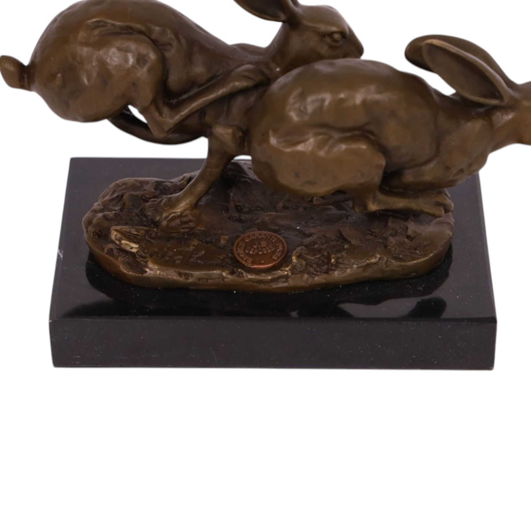 Bronze figure group, modelled two hares in chase, upon naturalistically modelled oval base signed Nick and with foundry mark, raised upon black marble base, H11cm L12.5cm