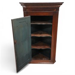 19th century mahogany corner wall cupboard, with projecting cornice and dentil moulding above a single door with shaped fielded panel and satinwood fan inlay, flanked by fluted pilasters, fitted with shaped interior shelving