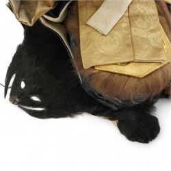 Two early 20th century Japanese 'Musha-ningyo' or Warrior Doll figures, costumed with distinctive armour and attributes, the first seated on lacquered red stool the other on a taxidermy rug, seated figure H44cm (2)