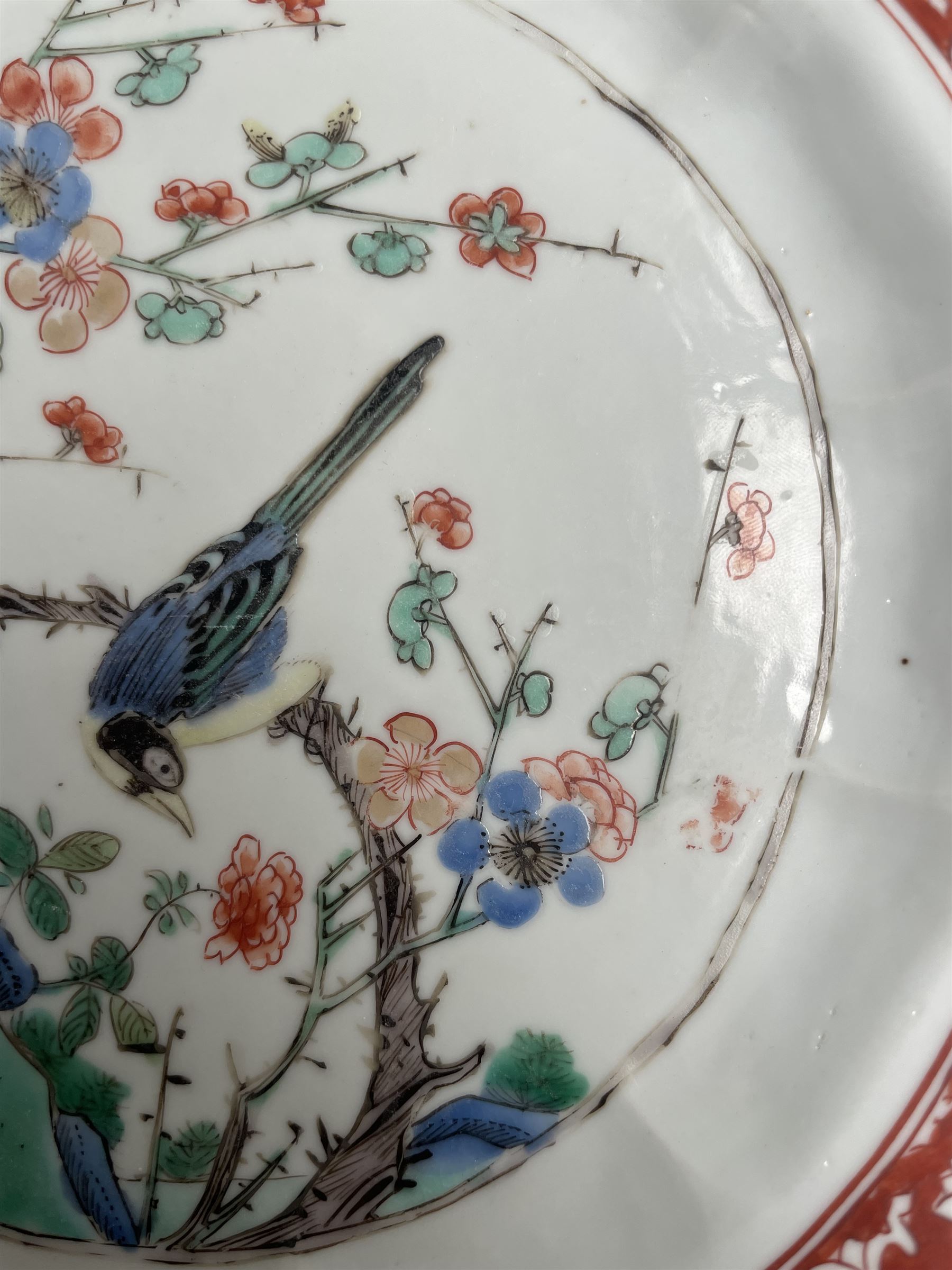 Chinese Kangxi famille verte plate, decorated with a bird perched upon a blossoming branch, within an iron red foliate border, D22cm