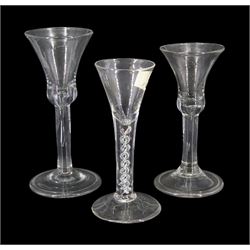 Three 18th century drinking glasses, two examples with bell shaped bowls upon stems with internal tears, one elongated, and folded conical feet, the third example with drawn trumpet bowl upon a single series mercury twist stem and conical foot, largest H17cm,