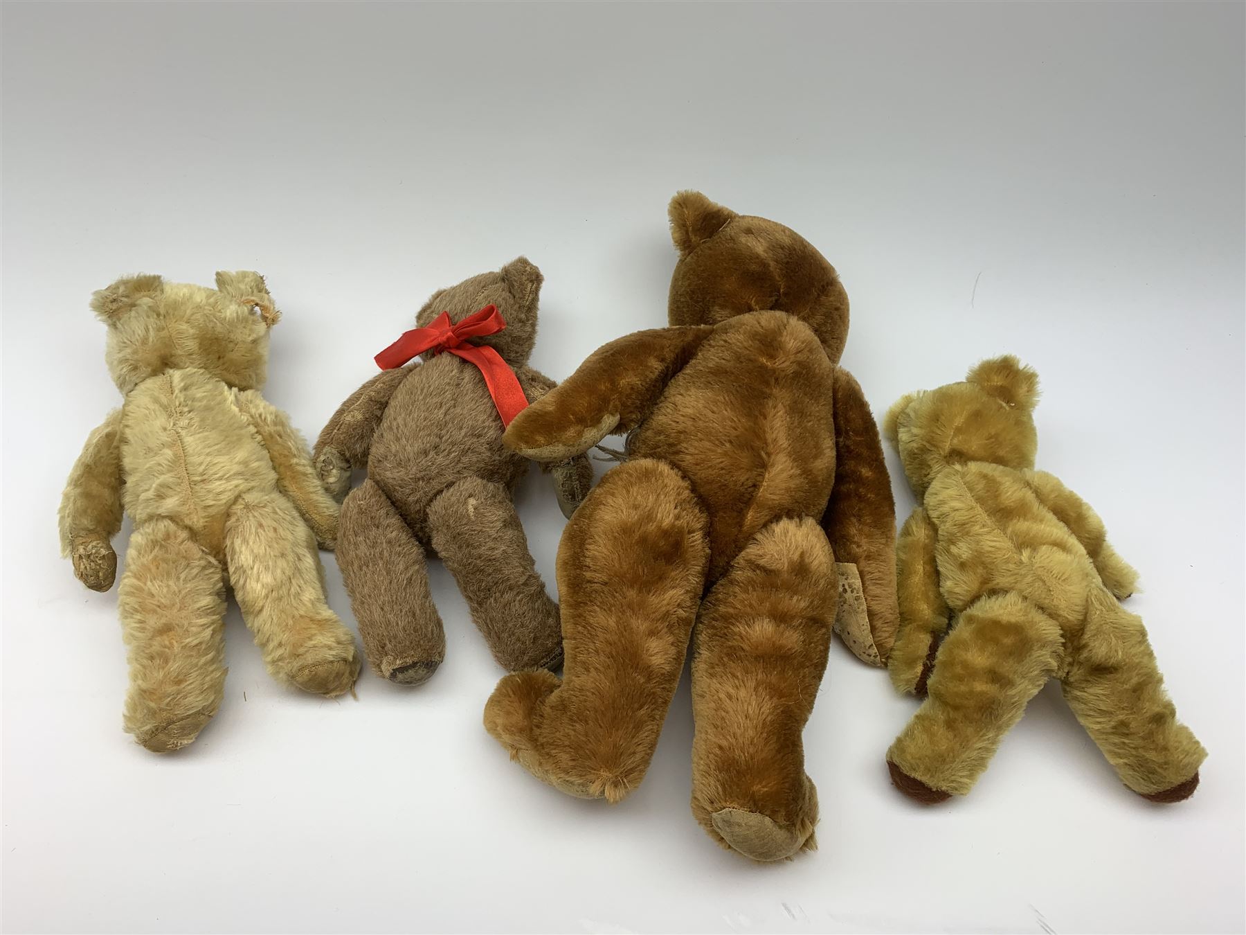 Four 1950s English teddy bears including a Chad Valley brown alpaca wool bear with swivel jointed head, glass type eyes, vertically stitched nose and mouth and jointed limbs H15