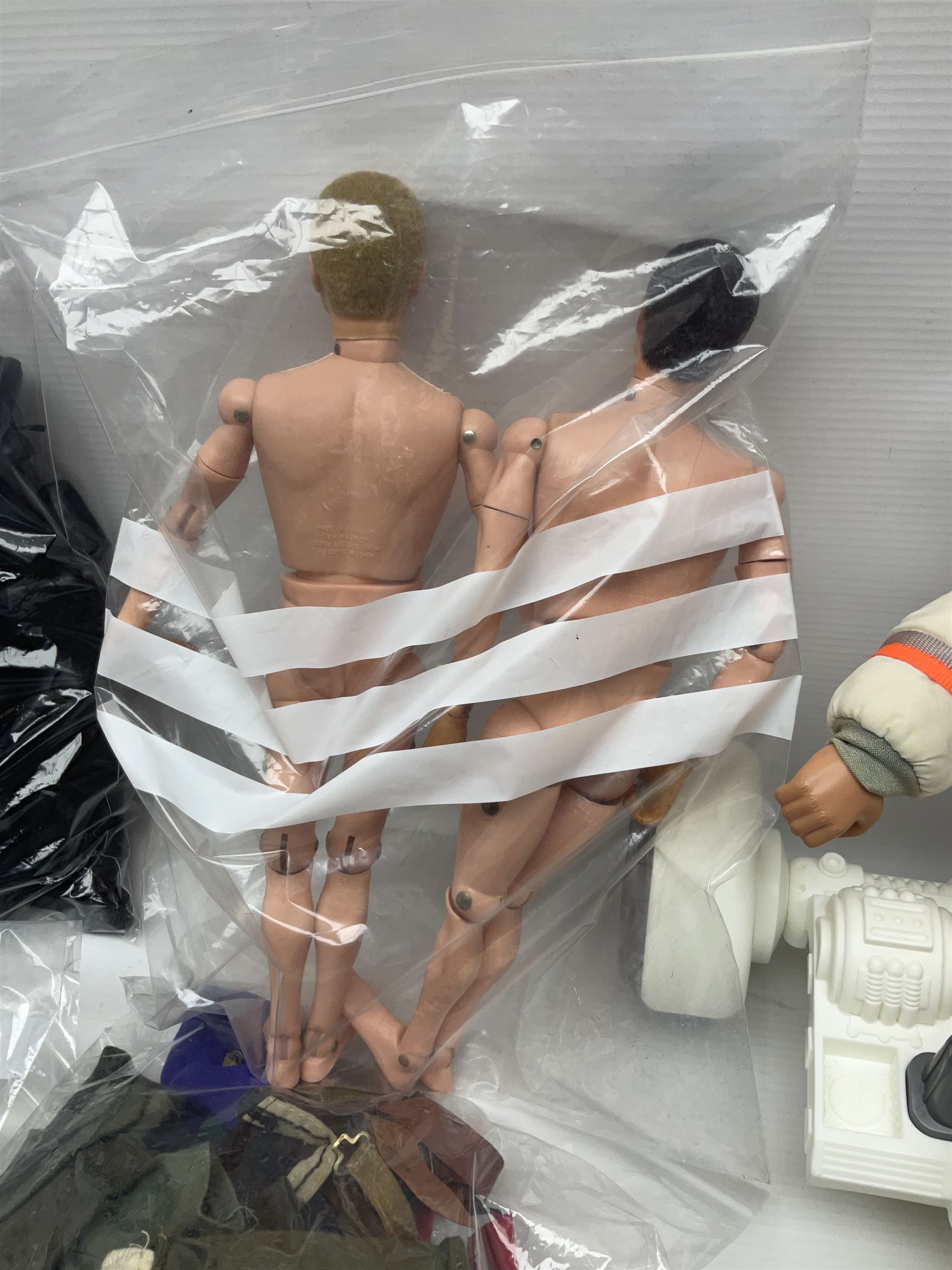 Action Man - large collection of 1960s and later figures and accessories including Spaceman with ATLRV vehicle; two figures marked 'Made in England by Palitoy under licence from Hasbro 1964'; twenty-five assorted weapons; radio backpacks; kit bags; twenty-one pairs of boots; football boots and snow shoes; metal diver's boots and three pairs of flippers; two pairs of jackboots; roller skates; various tunics, trousers, flying suits, jumpers, belts etc; twenty helmets, berets, busby, kepis, submariner etc; and quantity of other accessories
