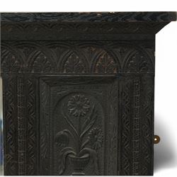 Victorian heavily carved oak wall mirror, lunette and foliage carved frieze over central bevelled mirror and flanking panels carved with floral urns, the upright frame decorated with geometric pattern chip carvings, lunette carved lower rail 