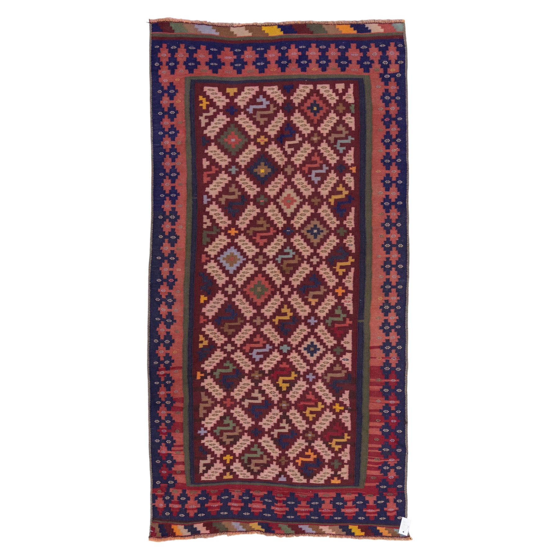 South West Persian Qashgai flatweave kilim, field decorated with a repeating diagonal lattice of stepped lozenges and angular hooked motifs, interspersed with small tribal devices, woven is shade of madder red, soft pink, indigo blue, ochre, and olive green, framed by a narrow geometric border and contrasting guard stripes 