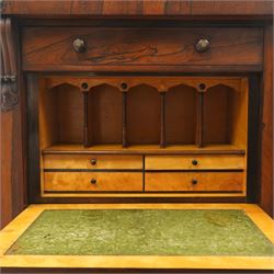 Victorian rosewood Wellington secretaire chest, the projecting stepped cornice over a banded frieze with moulded rosette mounts, single drawer over a secretaire fall-front opening to reveal a maple lined interior with assorted pigeonholes and correspondence drawers, over a lappet carved lower edge with four graduating drawers below, each with turned pull handles, flanked by hinged lock to the right and plain stile to the left surmounted by reeded corbels, raised on a skirted base