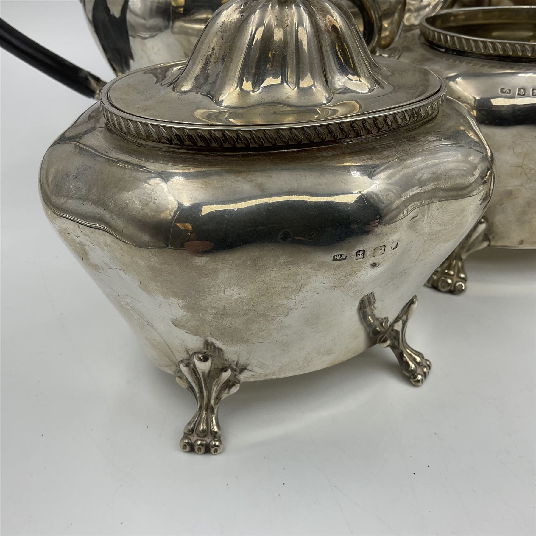 Five piece Edwardian silver tea service, comprising teapot and coffee pot, each with ebonised scroll handle, tea caddy with hinged cover, twin handled open sucrier, and milk jug, each of rounded bombe form, upon four paw feet, hallmarked William Adams Ltd, Birmingham 1904 and 1905, coffee pot H26cm
