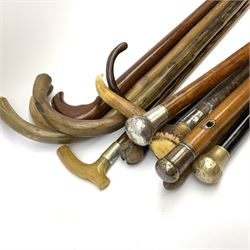 Collection of wooden walking sticks and canes, including horn handled stick with silver collar, three metal topped canes, five crook handled walking sticks etc .