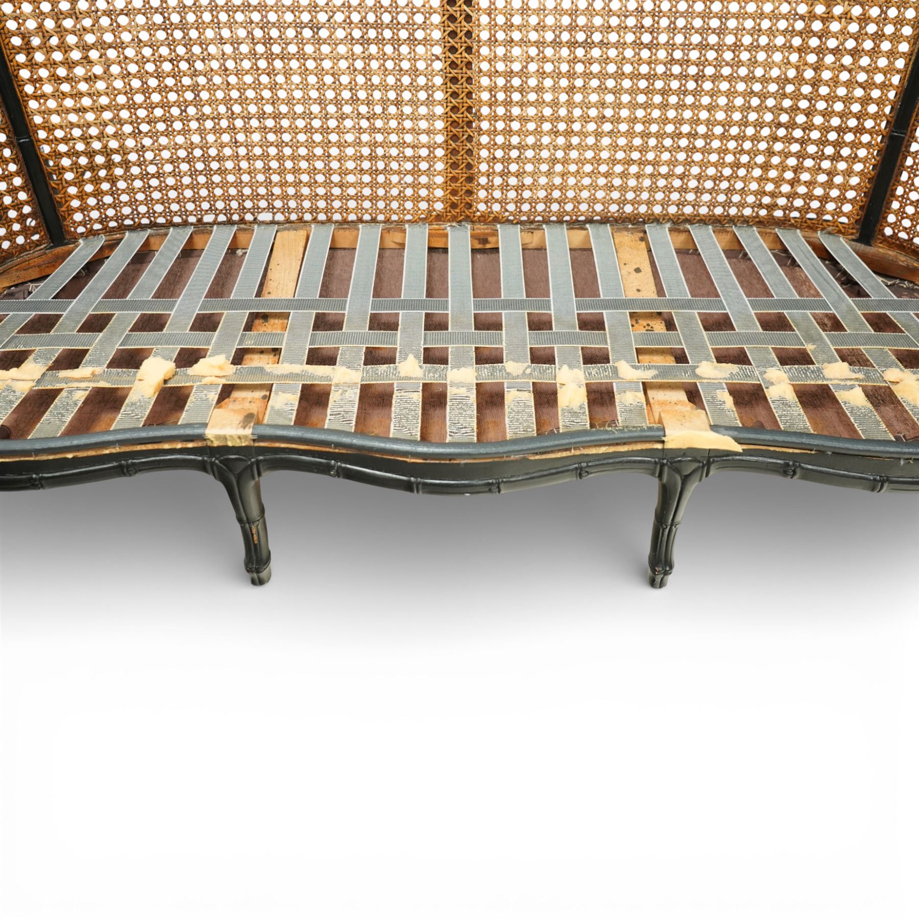 Early 20th century French bergère settee, the shaped caned back flanked by caned sides and scrolling arms, moulded beech frame with dark painted finish, serpentine seat rail with webbing, on cabriole legs with pad feet