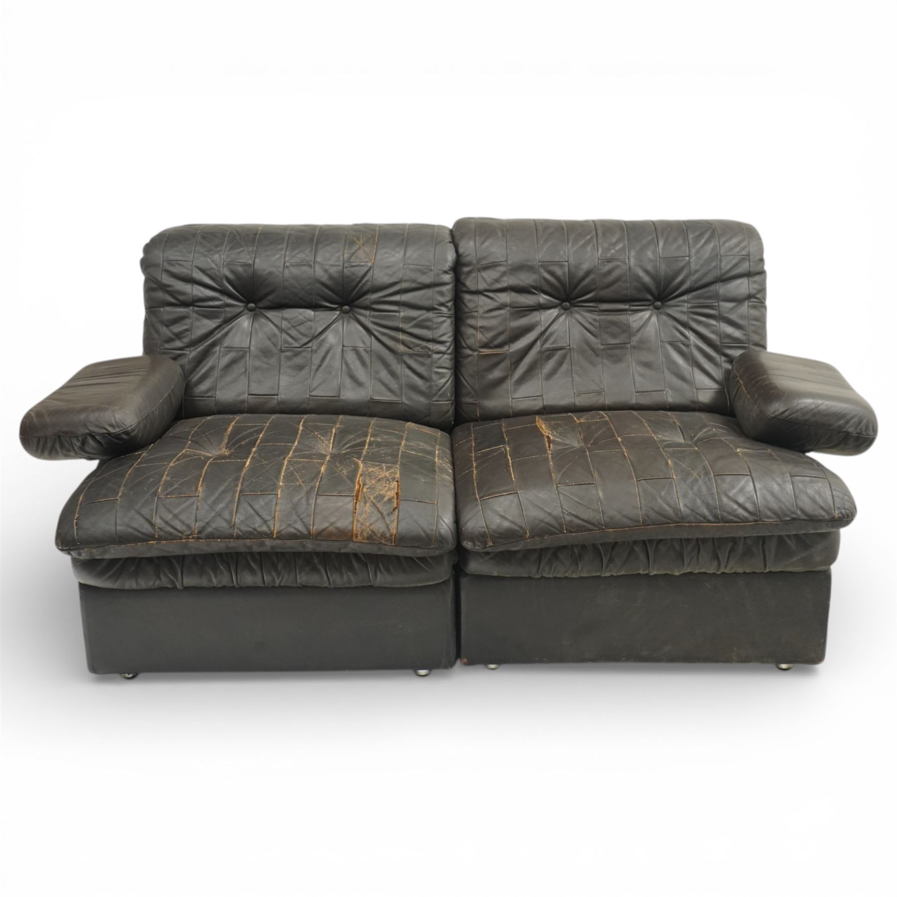 Mid 20th century leather upholstered two-piece sectional sofa with footstool, buttoned back cushions with stitched panel decoration, padded armrests and deep seat cushions, raised on concealed supports