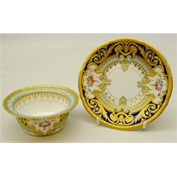  Royal Crown Derby ramekin and saucer from the Judge Elbert Henry Gary service, circa 1910, hand painted by Albert Gregory, signed, with baskets of flowers in cartouche shaped panels on cobalt blue and turquoise ground with raised gilded border incorporating an oval medallion with the initial 'G' by George Darlington, signed, printed backstamp in gilt with Royal Warrant and Tiffany & Co retailer's mark, saucer D12.5cm ramekin D9.5cm. Provenance Property of Bob Heath, Brandesburton Formerly of Ravenfield Hall Farm near Rotherham  