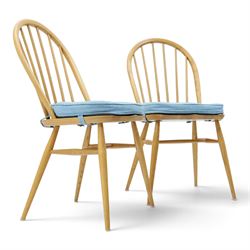 Ercol - pair of 'Windsor' dining chairs, with high hooped back, blue seat cushions with studded, tapered supports  