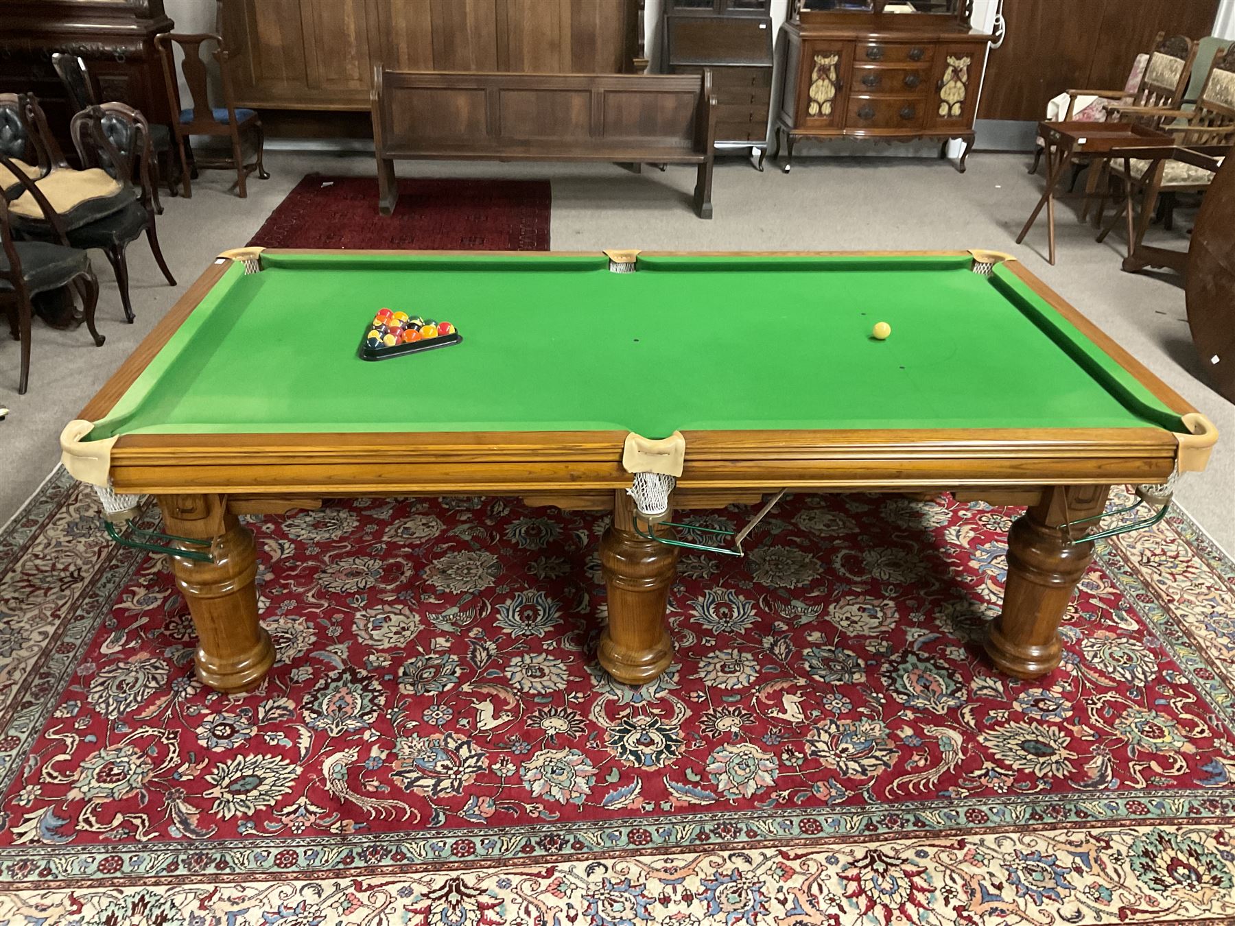 Late 20th century oak slate bed billiard table, on six turned column supports,  together with cues, ball set, baize brush, triangles and scoreboard 