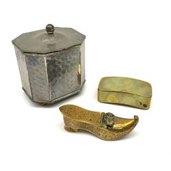 A 19th century brass three compartmented snuff box, of curved oblong form, L7.5cm, together with a later brass box in the form of a shoe, and an Arts and Crafts style Cobral Ware planished box, with canted corners and four bun feet, H10cm. (3). 