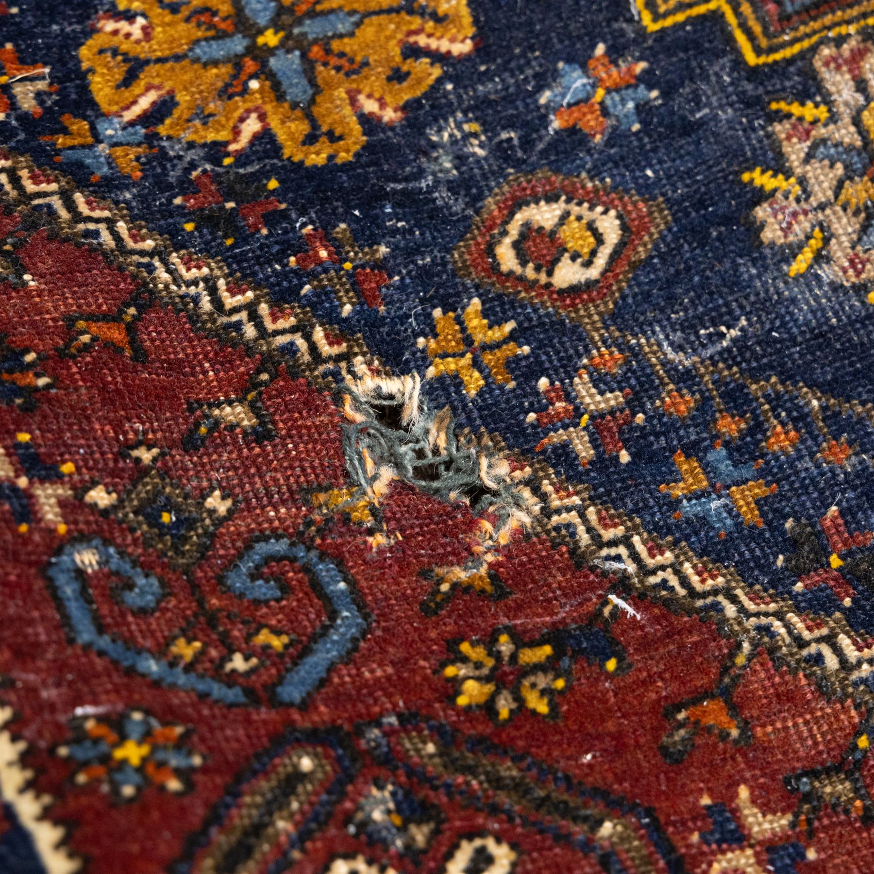 Turkish Anatolian wool rug, central stepped medallion on dark blue lozenge field, red spandrels with stylised hooked motifs, ochre border decorated with repeating geometric motifs and guard stripes