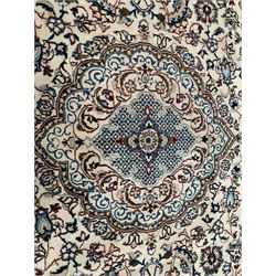 Large Persian Kashan ivory ground carpet, the field decorated with curled leafy branches with stylised plant motifs, shaped foliate design central medallion, the guarded border with repeating floral design 