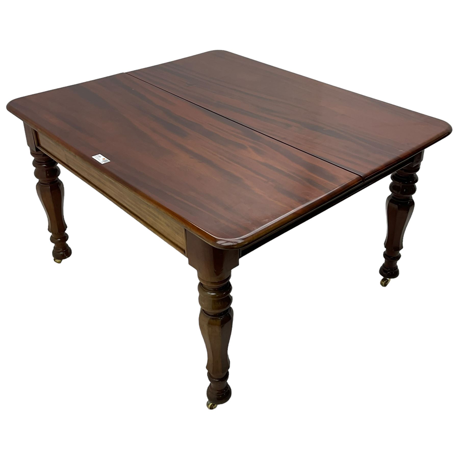 19th century mahogany extending dining table with three additional leaves, rectangular top with rounded corners, pull-out action, on turned and faceted supports with brass castors