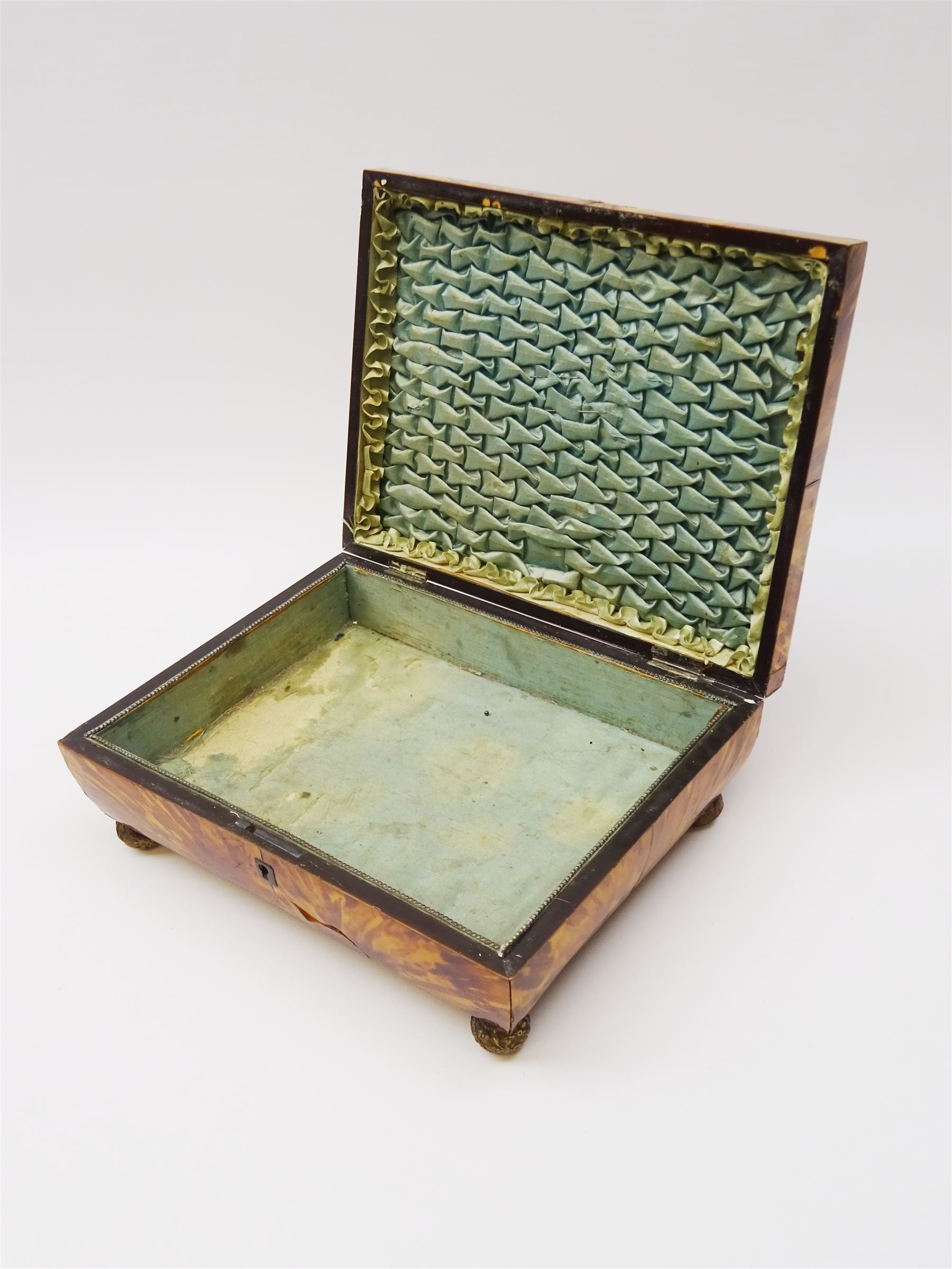 19th century tortoiseshell sewing box, of sarcophagal form upon four foliate detailed brass ball feet, the hinged cover edged in ivory with initialled silver plaque to centre, opening to reveal a silk lined interior, H9.5cm W22.5cm D18cm